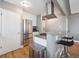 Well-lit kitchen featuring a bar, stainless appliances and sleek countertops, ideal for modern living and entertaining at 20 S Harrison St, Denver, CO 80209