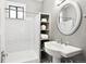 Bright bathroom featuring subway tile, a pedestal sink, and a large round mirror at 3316 N Columbine St, Denver, CO 80205