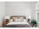 Cozy bedroom features stylish wallpaper, warm lighting, and a comfortable bed with decorative pillows at 3316 N Columbine St, Denver, CO 80205
