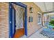 Inviting front porch with a blue door, brick facade, patterned wall paper, and modern outdoor light fixture at 3316 N Columbine St, Denver, CO 80205