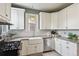 Modern kitchen features white cabinets, stainless steel appliances, subway tile backsplash and farmhouse sink at 3316 N Columbine St, Denver, CO 80205