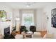 Cozy living room features a fireplace, two armchairs, modern ceiling fan, and large window with sheer curtains at 3316 N Columbine St, Denver, CO 80205