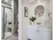Bathroom features a modern vanity with a round mirror, a glass-enclosed shower, and neutral decor at 4114 S Niagara Way, Denver, CO 80237