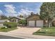 Charming brick home with a two-car garage and beautifully landscaped front yard on a sunny day at 4114 S Niagara Way, Denver, CO 80237
