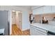 Hallway view featuring wood-look floors, closet, and entryways to the kitchen and living room at 4114 S Niagara Way, Denver, CO 80237
