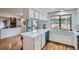 Bright kitchen features stainless steel appliances, white cabinets and countertops, and wood-look flooring at 4114 S Niagara Way, Denver, CO 80237