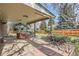 Covered outdoor patio with a stone and brick landscape, providing a comfortable area to relax in the backyard at 4114 S Niagara Way, Denver, CO 80237