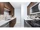 Well-lit kitchen featuring dark wood cabinets, stainless steel appliances, and a mosaic backsplash, offering both style and functionality at 16259 W 10Th Ave # I2, Golden, CO 80401