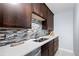 Close up view of a kitchen featuring dark wood cabinets, stylish countertops, and modern stainless steel appliances at 16259 W 10Th Ave # I2, Golden, CO 80401