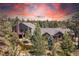 This aerial view features an estate home with mature landscaping including a pond and a stone chimney at 8361 Piney Creek Rd, Parker, CO 80138