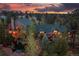 Aerial sunset view of an estate home with warm interior lighting and a tranquil pond at 8361 Piney Creek Rd, Parker, CO 80138