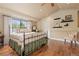 Bright bedroom featuring a brass bed frame, hardwood floors, and a decorative display shelf at 8361 Piney Creek Rd, Parker, CO 80138