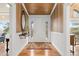 Elegant foyer featuring hardwood floors, wainscoting, designer wallpaper, a stylish console table, and a decorative mirror at 8361 Piney Creek Rd, Parker, CO 80138