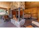 Covered outdoor area with stone fireplace, wood paneling, comfortable seating, and natural views at 8361 Piney Creek Rd, Parker, CO 80138