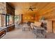 Covered outdoor living space featuring a stone fireplace, wood paneling, and comfortable seating at 8361 Piney Creek Rd, Parker, CO 80138