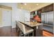 Modern kitchen island with seating, granite countertops, stainless steel appliances, and tile backsplash at 2001 Lincoln St # 2420, Denver, CO 80202