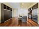 Modern kitchen with island seating, integrated murphy bed, hardwood floors, and stainless appliances at 2001 Lincoln St # 2420, Denver, CO 80202
