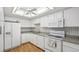 Well-lit kitchen featuring white cabinets, tile backsplash, and modern appliances at 13601 E Marina Dr # 604, Aurora, CO 80014