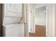 Hallway and laundry area with a stackable washer and dryer, and a view into the living room at 13601 E Marina Dr # 604, Aurora, CO 80014