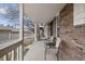 Covered front porch with seating area, with brick wall and white columns at 7272 E Appleton Cir, Centennial, CO 80112