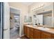 Bathroom featuring double sinks, a large mirror, and ample countertop space, leading into the bedroom at 7440 S Blackhawk St # 205, Englewood, CO 80112