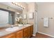 Bathroom featuring double sinks, a large mirror, and ample countertop space, and a bathtub in the background at 7440 S Blackhawk St # 205, Englewood, CO 80112