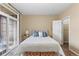 Bedroom with carpet, comfortable bed, bench, and balcony access with closet at 7440 S Blackhawk St # 205, Englewood, CO 80112