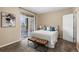 Bedroom with carpet, comfortable bed, bench, and balcony access with outdoor views at 7440 S Blackhawk St # 205, Englewood, CO 80112