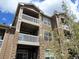 Low angle shot of a multi-story exterior with stone accents and private balconies at 7440 S Blackhawk St # 205, Englewood, CO 80112