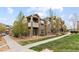 Charming two-story brown home with stone accents and a cozy balcony, surrounded by lush landscaping at 7440 S Blackhawk St # 205, Englewood, CO 80112