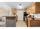 Well-lit kitchen with tile floors, wooden cabinets, and black appliances at 7440 S Blackhawk St # 205, Englewood, CO 80112