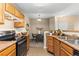 Open kitchen view with wooden cabinets and a dining area at 7440 S Blackhawk St # 205, Englewood, CO 80112