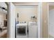 Bright laundry area features a full size washer, dryer, shelving, and storage space at 7440 S Blackhawk St # 205, Englewood, CO 80112