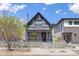 Charming gray two-story home with a fence, lush landscaping, and inviting front porch at 2135 W 40Th Ave, Denver, CO 80211