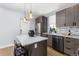 Kitchen with an island, stainless steel appliances, gray cabinets, and modern pendant lights at 2135 W 40Th Ave, Denver, CO 80211