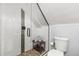 Modern bathroom with a glass-enclosed shower featuring white tile walls, a pebble floor, and a comfortable bench at 2135 W 40Th Ave, Denver, CO 80211