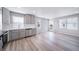 An open concept kitchen and dining area with stainless steel appliances and light hardwood flooring at 46566 Avery Ln, Bennett, CO 80102
