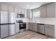 This is a modern kitchen with stainless steel appliances and gray cabinets at 46566 Avery Ln, Bennett, CO 80102