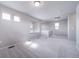 Empty living room showcasing neutral walls, carpet flooring, multiple windows, and natural light at 46566 Avery Ln, Bennett, CO 80102