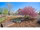 Backyard garden with mulch ground cover, raised garden beds, and flowering trees at 6800 Saddleback Ave, Firestone, CO 80504
