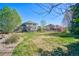 Sprawling backyard featuring mature trees, covered patio, and privacy fencing at 6800 Saddleback Ave, Firestone, CO 80504