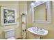 Bathroom with pedestal sink, toilet, and a framed picture on the wall at 6800 Saddleback Ave, Firestone, CO 80504