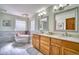 Luxurious bathroom features a soaking tub, dual vanities, modern fixtures and stylish lighting at 6800 Saddleback Ave, Firestone, CO 80504