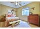 Cozy bedroom features a comfortable bed with decorative pillows, vintage dressers, and a ceiling fan at 6800 Saddleback Ave, Firestone, CO 80504