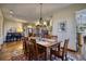 Open-concept dining area with hardwood floors and stylish chandelier at 6800 Saddleback Ave, Firestone, CO 80504
