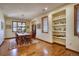 Bright dining room with hardwood floors, built-in shelving, and large windows at 6800 Saddleback Ave, Firestone, CO 80504