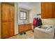 Well-lit laundry room with tile floors, wooden cabinets, sink, and modern washer appliance at 6800 Saddleback Ave, Firestone, CO 80504