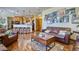 Inviting living room open to the kitchen boasts hardwood floors and a leather sofa with a gallery wall at 6800 Saddleback Ave, Firestone, CO 80504