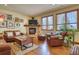 Comfortable living room featuring a stone fireplace, hardwood floors, and plenty of natural light at 6800 Saddleback Ave, Firestone, CO 80504