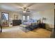 Spacious primary bedroom with a ceiling fan, comfortable seating, and a large window with natural light at 6800 Saddleback Ave, Firestone, CO 80504